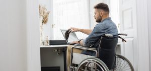 Image about disable man on wheel chair watching laptop screen