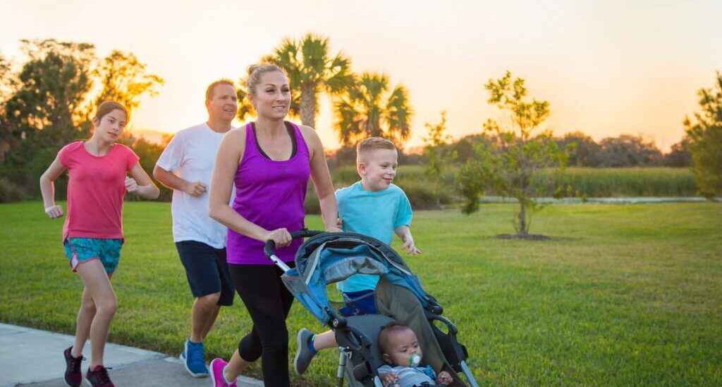 Cancer Hero2 scaled 1 1024x683 1 Can You Get Cancer Insurance for Employees in a Group Plan? The image shows a family of five walking or running with a child in a stroller