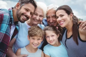 Portrait of happy multi generation family standing outdoors 1 Can You Get Cancer Insurance for Employees in a Group Plan? This image shows a group of people looking at the camera