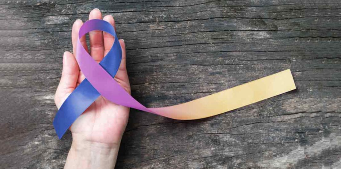 cervical cancer insurance policy Why Should You Offer Cancer Insurance to Your Employees? The image shows a hand holding a ribbon with three colours: blue, purple, and yellowish orange