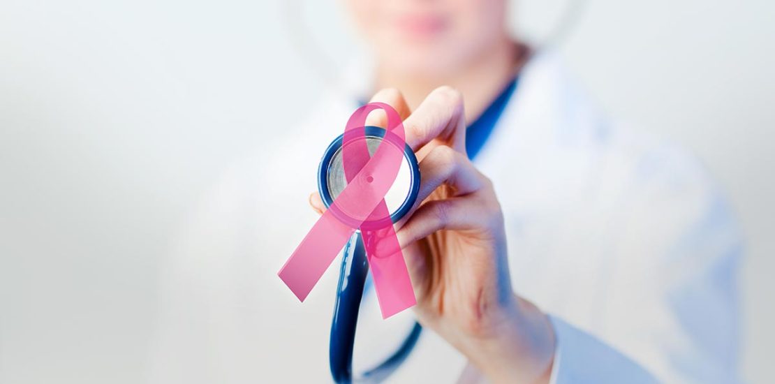 A doctor holding a stethescope with a ribbon that represents cancer