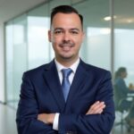 employee benefits renewal 60 days early medcore Your Employee Benefits Renewal Should Arrive 60 Days Early — Here's Why Employee benefits broker standing confidently in an office as colleagues meet in the background, illustrating a timely benefits renewal